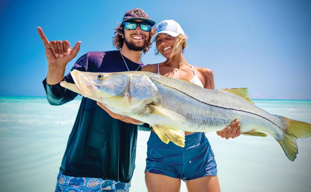 Adam and Anika Mellusi show off a giant Jupiter beach–caught snook. Photo by George LaBonte