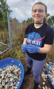 Bianca Bernhard sorts discarded oyster shells. Photo by MORI Photos